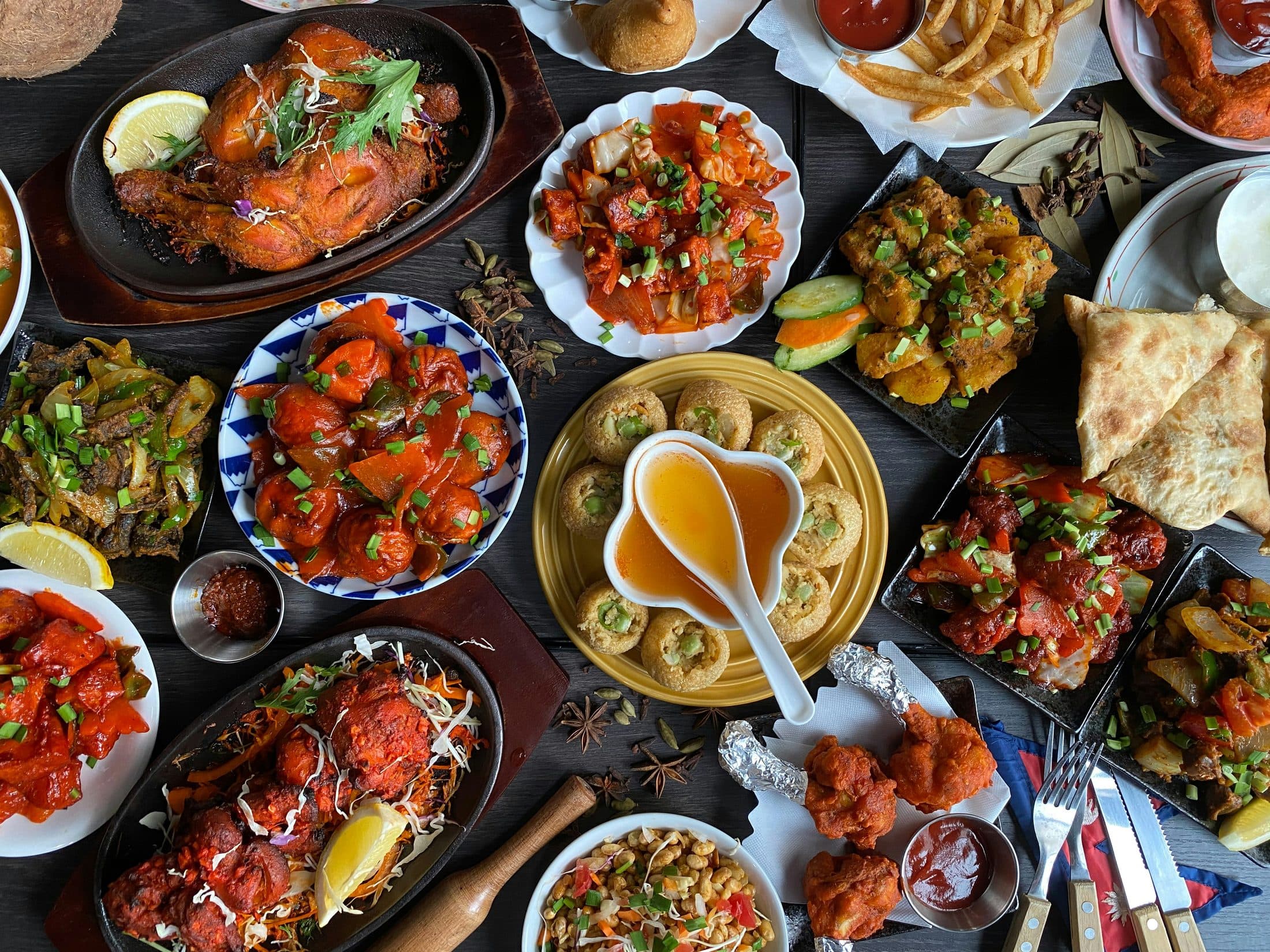 Overhead flat-lay of an Indian food spread with various dishes